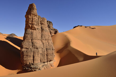 Algerien, Tassili n' Ajjer, Tadrart, Sahara, Tassili n' Ajjer National Park, Blick auf Sanddünen und Felsen von Moul Nag mit Menschen im Hintergrund - ES001029
