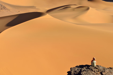 Algeria, Tassili n' Ajjer, Tadrart, Sahara, Tassili n' Ajjer National Park, woman looking to sand dunes of Moul Nag stock photo