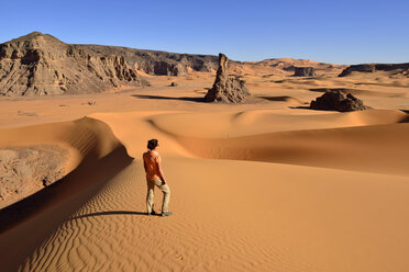 Algeria, Tassili n' Ajjer, Tadrart, Sahara, Tassili n' Ajjer National Park, woman in front of sanddunes and rocks of Moul Naga - ES001043