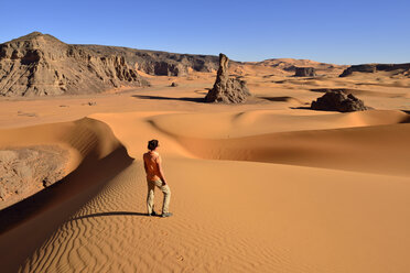Algerien, Tassili n' Ajjer, Tadrart, Sahara, Tassili n' Ajjer National Park, Frau vor Sanddünen und Felsen von Moul Naga - ES001043