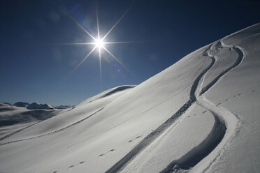 Austria, Kitzbuehel, snow with ski tracks against the sun - TMF000015