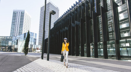 Spain,Catalunya, Barcelona, young modern woman with yellow jacket on the move - EBSF000202