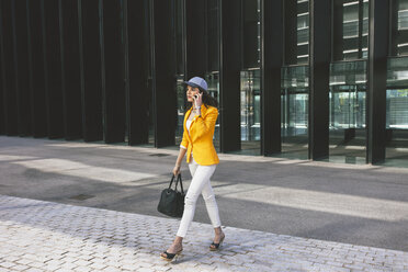 Spain,Catalunya, Barcelona, young modern woman with yellow jacket on the move - EBSF000192
