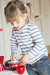 Little girl playing with children's kitchen - LVF001174