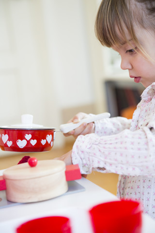 Kleines Mädchen spielt mit Kinderküche, Teilansicht, lizenzfreies Stockfoto