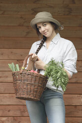 Junge Frau hält Korb mit Gemüse - SGF000636