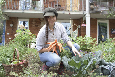 Young woman with carrots in vegetable garden - SGF000633