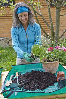 Reife Frau bei der Gartenarbeit - AKF000375