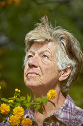 Senior woman in garden looking up - AKF000370