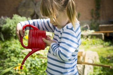 Kleines Mädchen bewässert Pflanzen im Garten - LVF001185