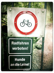 Prohibited Cycling and dogs on a leash signs at gate, Landhut, Bavaria, Germany - SARF000580