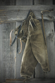 Lederhose und Spazierstock an einer Holzwand hängend - ASF005353