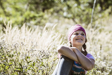 Girl sitting in meadow - HHF004797