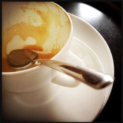 Coffee spoon in empty coffee cup with cappuccino residues - SRSF000470