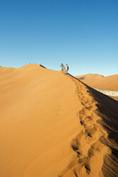 Afrika, Namibia, Sossusvlei, Gruppe von Menschen wandern in den Sanddünen - HLF000473
