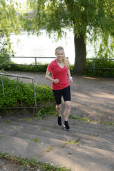 Junge Frau joggt auf einer Treppe - BFRF000407