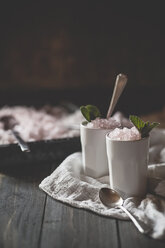 Zwei Tassen rosa Limonade Granita mit Minzblättern auf Tuch und Holztisch - SBDF000877