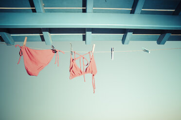 Bikini hanging on clothes line under the roof - KRPF000456