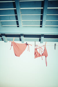 Bikini hängt auf der Wäscheleine unter dem Dach - KRPF000458