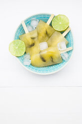 Bowl of caipirinha ice lollies, ice cubes and slices of lime - LVF001222