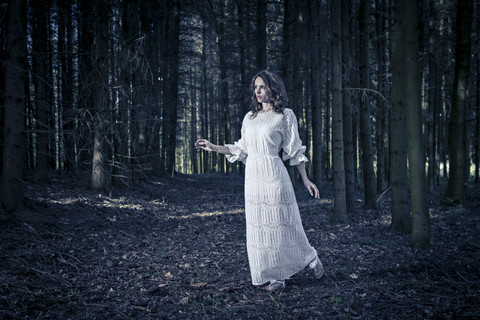 Woman wearing white dress in a forest stock photo