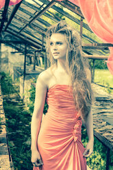 Young woman wearing evening dress standing in old greenhouse - FCF000201