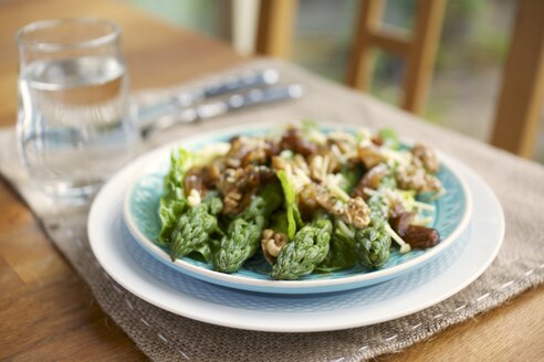 Grüner Spargel, Dattel- und Walnusssalat mit veganem Käse auf dem Teller - HAWF000171