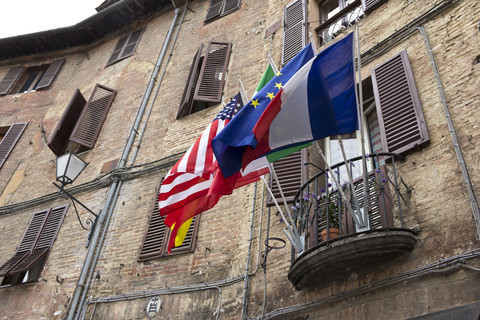 Italien, Toskana, Siena, Verschiedene Fahnen auf einem Balkon, lizenzfreies Stockfoto