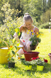 Teenage girl repotting plant in the garden - WWF003298