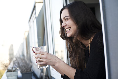 Woman with glass and cigarette leaning out a window - FEXF000073