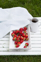 Holzschale mit Erdbeeren, Gefäß und Tuch im Garten - LVF001251