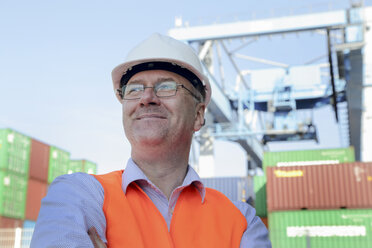 Porträt eines lächelnden Mannes vor einem Frachtcontainer - SGF000689