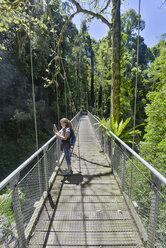Australia, New South Wales, Dorrigo, girl standing on a suspension bridge in the rainforest of the Dorrigo National Park - SHF001330