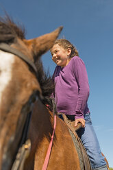 Australien, New South Wales, Dorrigo, Mädchen sitzt auf einem Pferd, Teilansicht - SHF001331