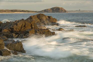 Australia, New South Wales, Tweed Shire, splashing breakwater at the rocky shore of Hastings Point in the first morning light - SHF001321