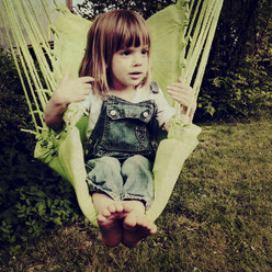 Germany, Baden-Wuerttemberg, girl in swing seat, garden - LVF001264