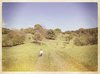 Germany, Baden-Wuerttemberg, near Tuebingen, little girl running through meadow - LVF001265