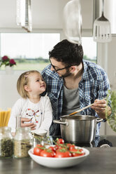 Father and daughter cooking in kitchen - UUF000498