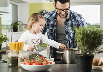 Vater und Tochter kochen in der Küche - UUF000479