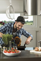 Young man cooking in kitchen at home - UUF000483