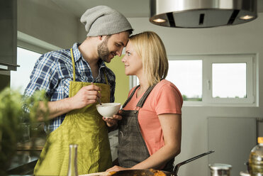 Verliebtes Paar beim Kochen in der Küche zu Hause - UUF000522