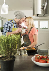 Verliebtes Paar beim Kochen in der Küche zu Hause - UUF000525
