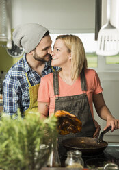 Verliebtes Paar beim Kochen in der Küche zu Hause - UUF000526