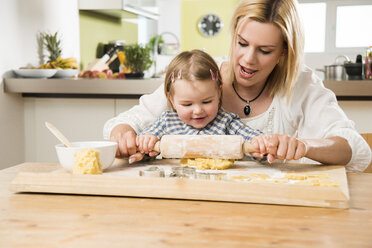 Mother and daughter baking in kitchen at home - UUF000534