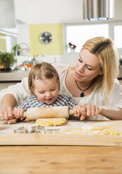 Mother and daughter baking in kitchen at home - UUF000499