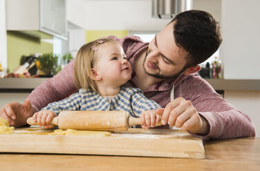 Father and daughter baking in kitchen - UUF000543