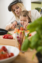 Mutter und Tochter kochen in der Küche zu Hause - UUF000553