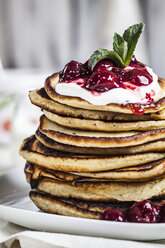 Stack of American pancakes with cherry sauce and greek yogurt, close-up - SBDF000924