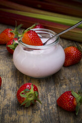 Glas mit Erdbeerjoghurt, Erdbeeren und Rhabarber auf dunklem Holz - LVF001255