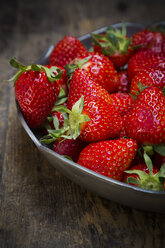 Metal bowl of strawberries on dark wood - LVF001260